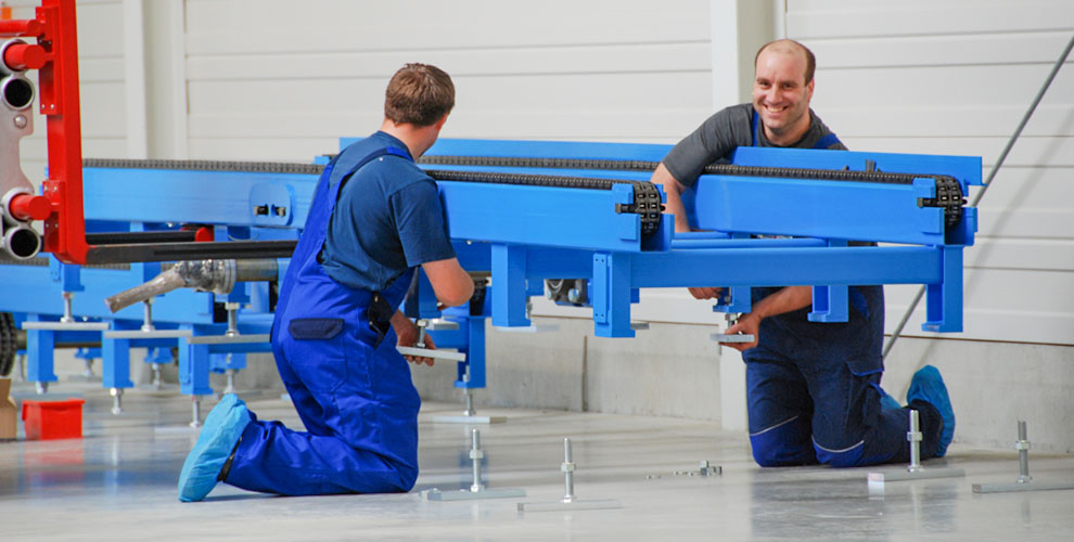two employees assemble conveyor system