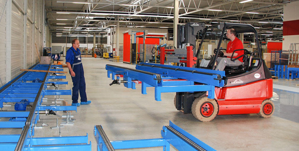 red lift truck transports blue parts of a conveyor system